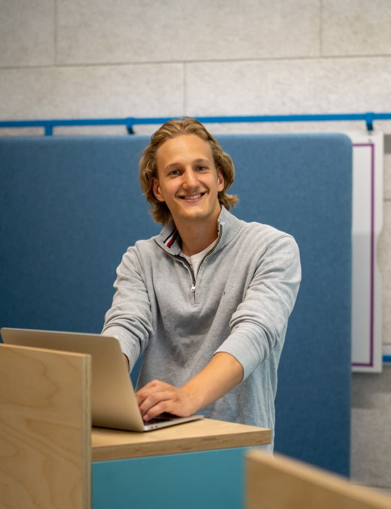 Tjark Bauer, Gründer von Fotos Erwecken, lächelnd am Laptop